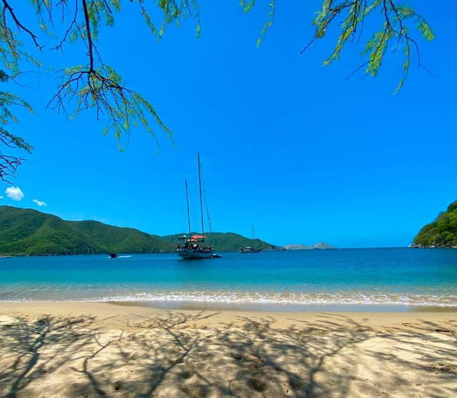 Imagen panorámica espectacular de Bahía Concha en el Parque Tayrona mostrando sus aguas cristalinas turquesas y exuberante vegetación tropical