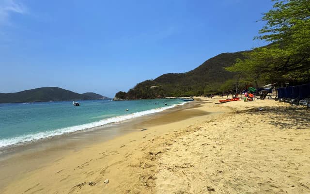 Lancha navegando hacia Playa Cristal en el Parque Tayrona mostrando las aguas turquesas cristalinas y la experiencia marítima única