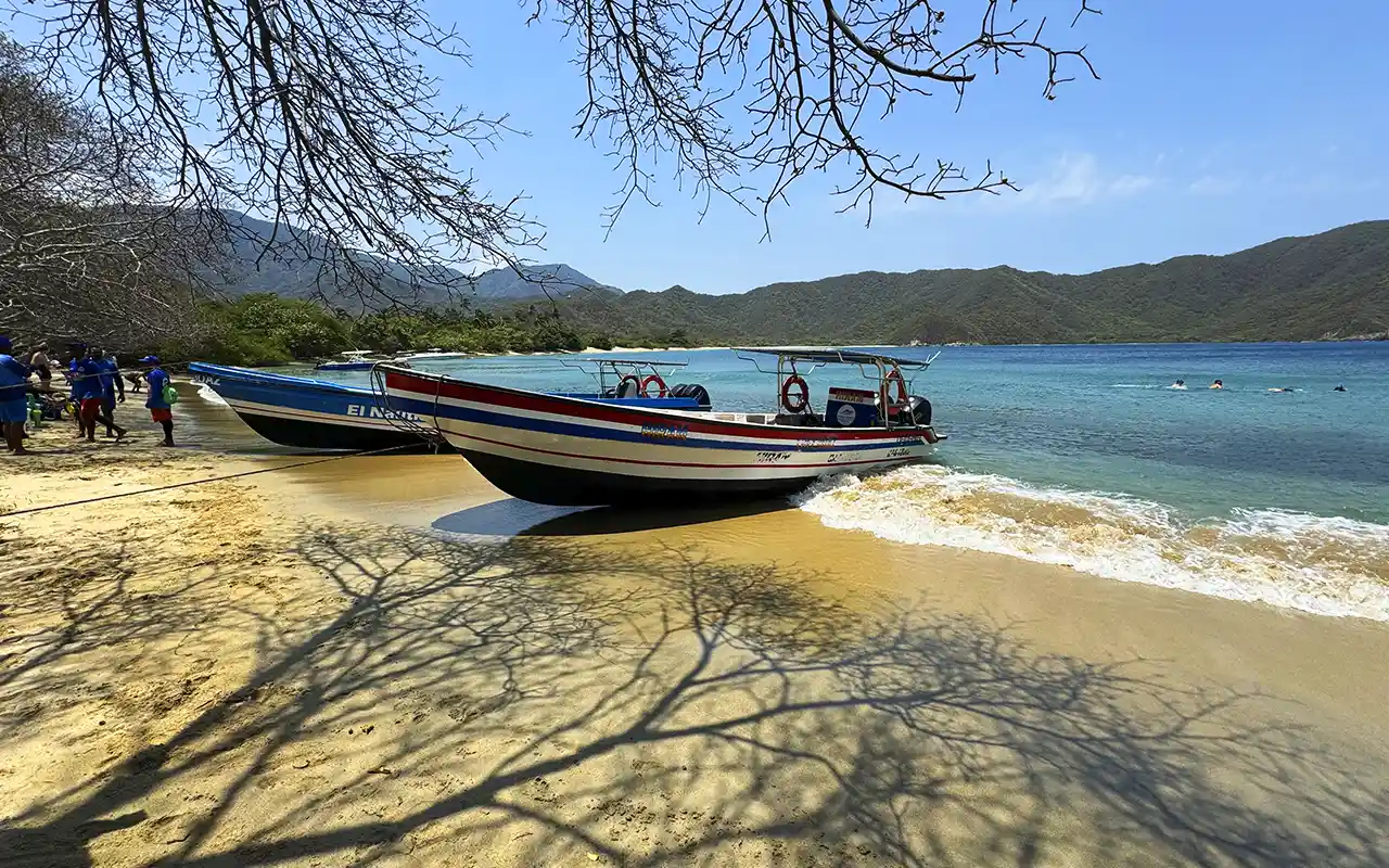 Boats beached on the golden sand at Bahía Concha, calm water and swimmers